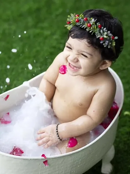 It's me time. This little one is having a blast in a bubbly milk bath with rose petals, a beautiful and fun idea for an outdoor baby shoot.