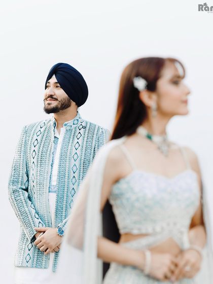 An artistic shot using focus to create depth. With the groom in sharp focus and the bride softly blurred in the foreground, this portrait tells a story of admiration and love.