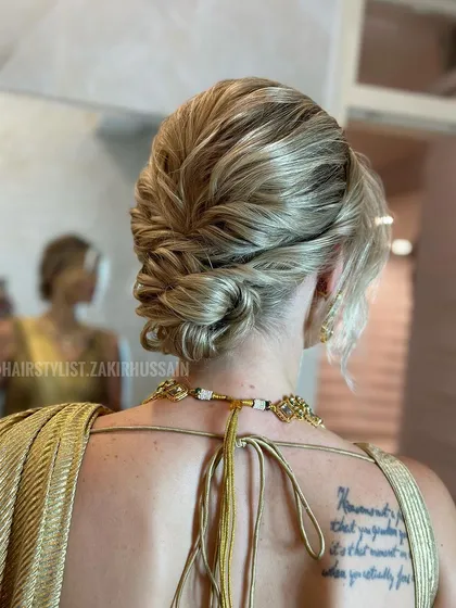 A closer look at the textured blonde updo, showing the intricate twists and folds that create its unique shape.
