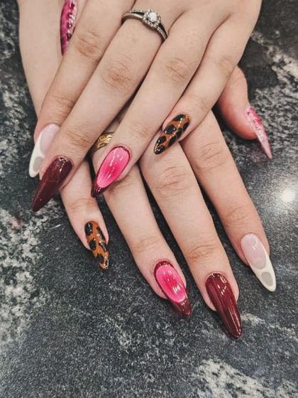 For the bold and confident. This dramatic nail art combines deep burgundy, fierce leopard print, and a unique 3D jelly pink design on long, stiletto-shaped nails for a true statement look.