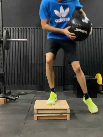 A plyometric drill involving a medicine ball and a box jump. This combines upper and lower body power, teaching the athlete to coordinate their entire body for maximum explosive output.