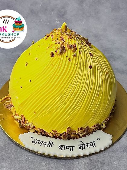Our signature modak cake for Ganesh Chaturthi, shaped like the traditional sweet and garnished with chopped nuts. It's a delicious centerpiece for your puja.