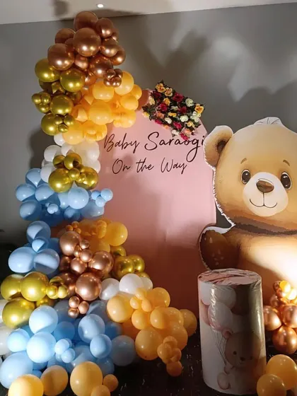 Another view of the adorable teddy bear themed baby shower. The balloon garland in blue, yellow, and chrome gold adds a festive touch to the celebration.