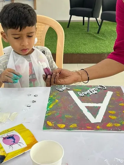 An instructor helps a young participant with his canvas, ensuring he has all the support he needs to bring his creative vision to life.