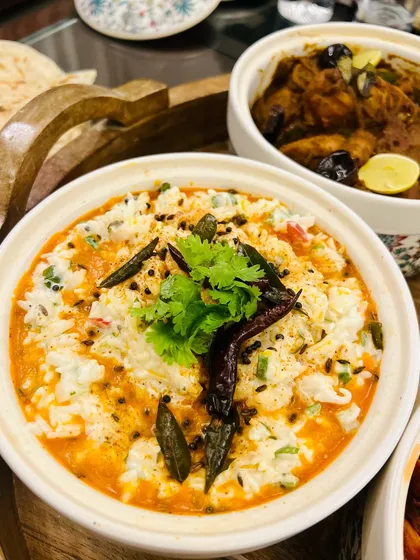 A close-up of our tempered Curd Rice, a comforting and classic South Indian dish. It's the perfect accompaniment to our spicy Chettinad and Ghee Roast preparations.