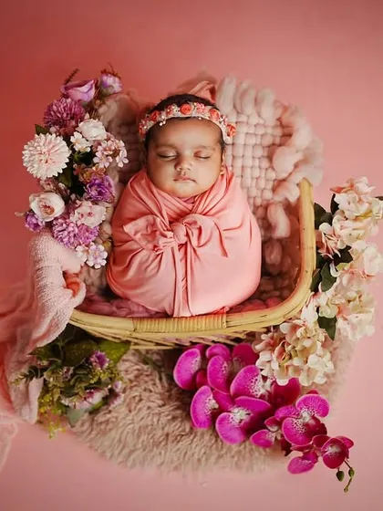 An overhead shot of the floral bassinet setup, showcasing the beautiful arrangement of flowers and fabrics that create a cozy nest for the baby.