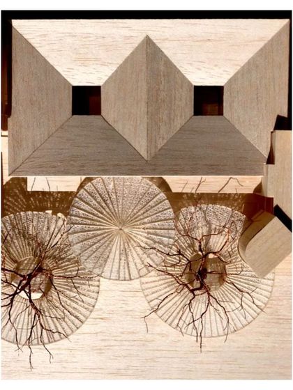 The model highlights the central block around which the other pods pivot, with the intricate canopies casting shadows. This view emphasizes the geometric and organizational principles of the master plan.