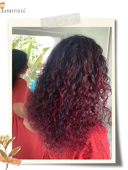 A close-up of these captivating deep red magenta curls. The color is rich and vibrant, bringing the hair to life with a mesmerizing charm.