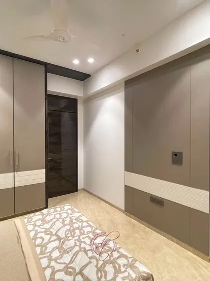 This shot showcases the custom wardrobes and their two-tone design. The seamless, handle-less finish contributes to the room's minimalist and sophisticated feel.