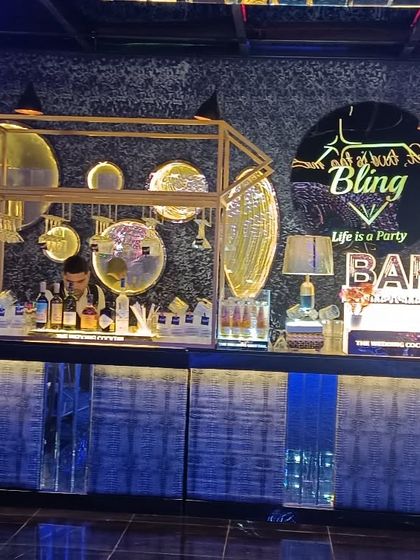 The 'All About Bling' bar setup, featuring a textured blue facade, gold accents, and artistic lighting, designed for a high-energy party atmosphere.