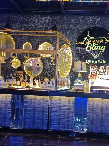 The 'All About Bling' bar setup, featuring a textured blue facade, gold accents, and artistic lighting, designed for a high-energy party atmosphere.