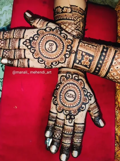 A clear view of a 'Boy or Girl' themed mehandi for a baby shower. The design uses bold, circular frames to highlight the text, complemented by traditional patterns on the arm.