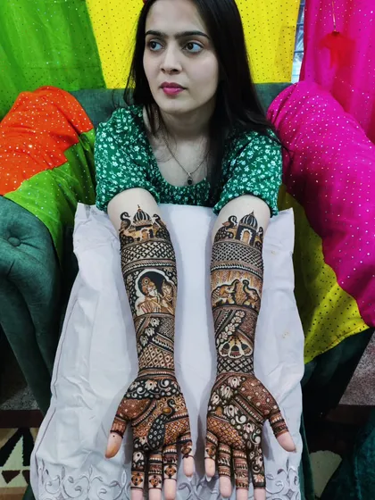A beautiful bride posing with her full-arm story mehandi, ready for her wedding celebrations.