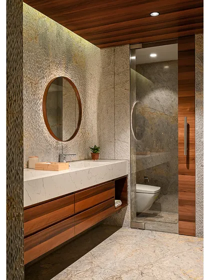 A bathroom should be a personal retreat. We used rustic, scratch-finish marble on the walls and floor, a warm wood vanity, and a custom concrete basin to give this space a raw, earthy, and deeply luxurious feel.