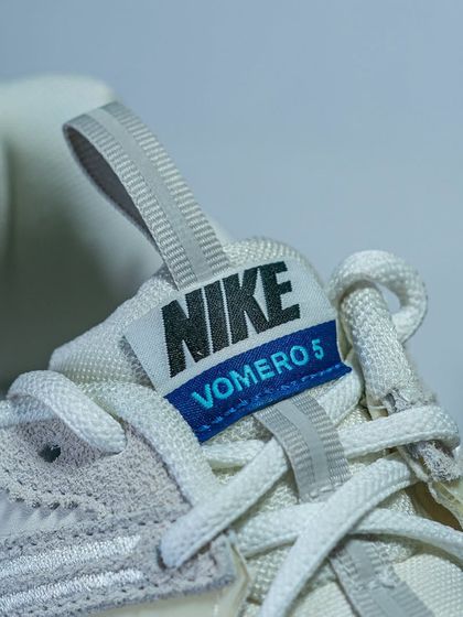Detail shot of the tongue tag on the Nike Zoom Vomero 5, a nod to its early 2000s running heritage.