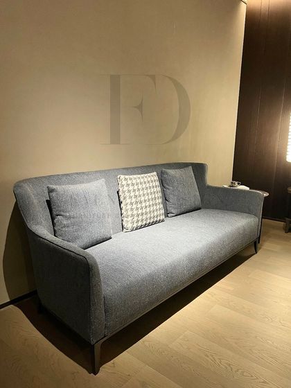 A simple yet elegant sofa in a textured blue fabric. Its clean lines and tapered wooden legs make it a versatile choice for a modern living room, offering comfort without overwhelming the space.