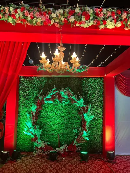 The view from inside the red entrance tunnel, looking out at the circular floral wreath on the greenery wall. This was designed as a perfect spot for welcome photos.