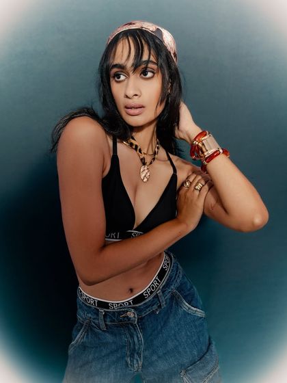 A classic fashion pose that showcases the outfit and accessories. The model's expression is both soft and confident.