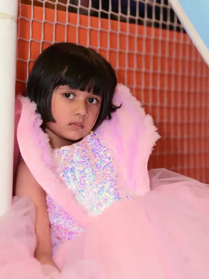 A portrait of the birthday girl in her beautiful pink sequin and tulle dress.