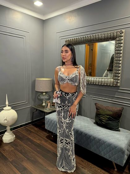 The full look of the charcoal black ensemble, where an ethereal cape adds a touch of flowing charm.