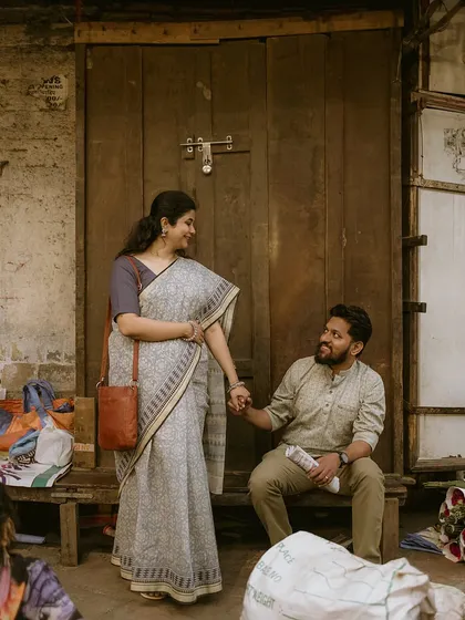 Creating a story with an old-school vibe in a bustling city market. The simple act of holding hands while seated on a wooden bench tells a tale of simple, enduring love, embodying the 'marathi old is gold' spirit.