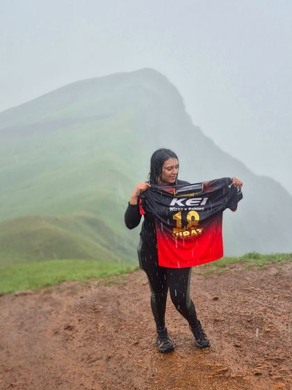 Another shot of a trekker with an RCB jersey, showing her support against the stunning backdrop of Netravathi.