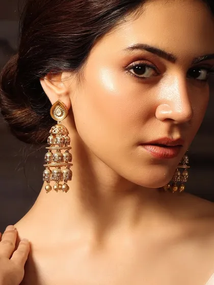 A close-up of our tiered golden jhumkas, worn by Pashmina Roshan, featuring delicate craftsmanship perfect for any celebration.