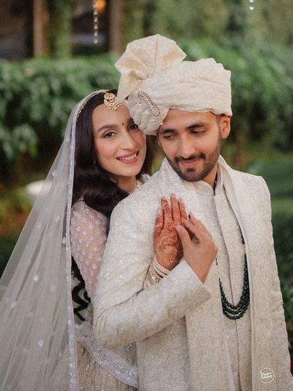 A sweet and classic wedding portrait. The bride's gentle touch and the couple's happy expressions capture the love and partnership at the heart of their celebration.