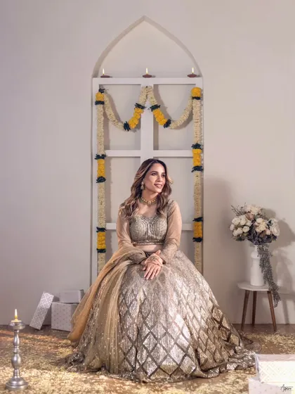 A full view of our festive set design in the studio. The traditional decor with marigold garlands and diyas creates a warm and celebratory atmosphere for this ethnic fashion portrait.