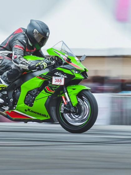 A vibrant green Kawasaki Ninja ZX-10R at speed. These superbikes are a crowd favorite, known for their incredible power and distinctive engine roar.