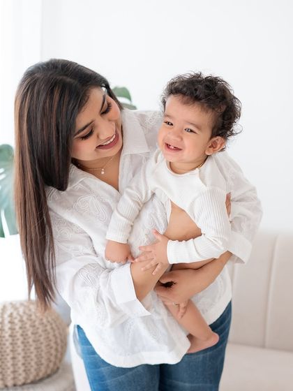 A mother and her baby sharing a happy, candid moment in the studio.