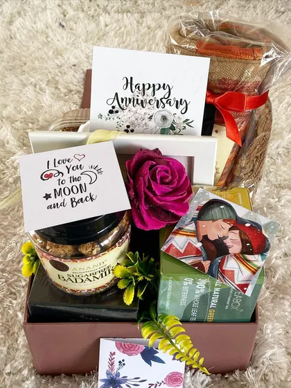 Celebrate your journey together with a romantic anniversary hamper. This gift box is filled with love, featuring sugar-free sweets, a "Happy Anniversary" card, a personal "I Love You to the Moon and Back" note, and other curated items to make your special day even more memorable.