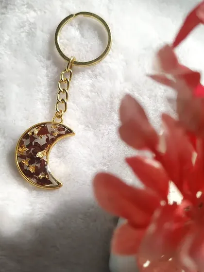 This crescent moon keychain is another popular design for preserving rose petals. The delicate gold-toned moon shape is filled with petals and gold flakes, creating a celestial, romantic look.