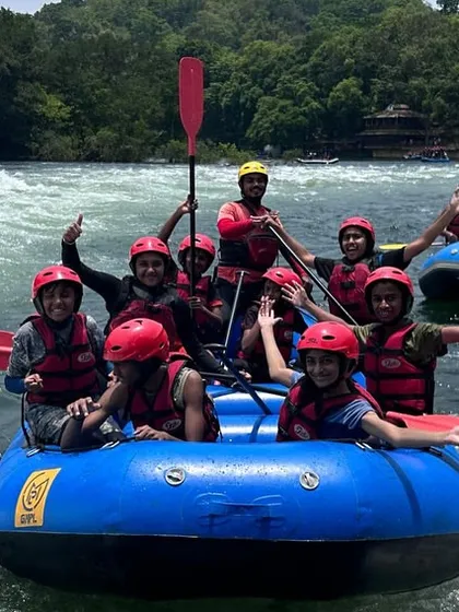 Two rafts full of excited kids from our summer camp wave for the camera on the Kali River. We ensure even our youngest adventurers experience the thrill of rafting safely.