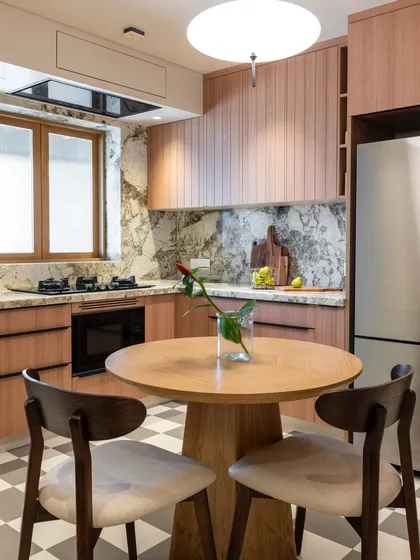 A kitchen should be a place where life unfolds naturally. Here, the kitchen flows into a cozy dining nook, creating a warm, inviting space for morning coffee or quiet meals. The soft wood tones and marble backsplash come together to form a gentle, modern aesthetic.