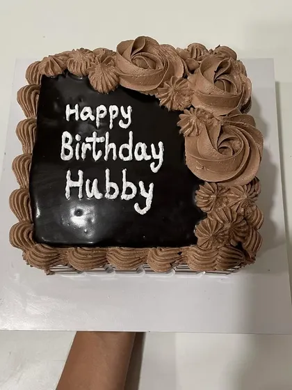 A square chocolate cake for a hubby's birthday. This design features a rich ganache top and chocolate cream piping.