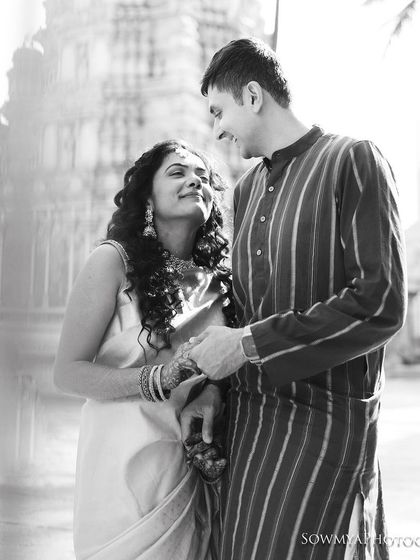 A classic black and white pre-wedding portrait in a historic location. The couple's loving gaze and the timeless feel of the image create a romantic narrative.