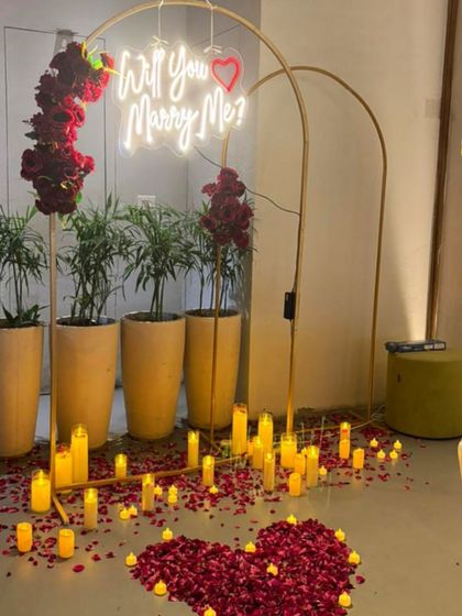 Here is a clear view of an intimate indoor proposal setting I designed. The focus is on the romantic elements like the glowing neon sign, the path of LED candles for safety and ambiance, and the rich red of the rose petals.