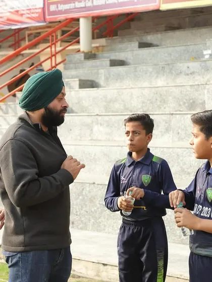 A coach provides a mid-match briefing to two young players. These tactical discussions are vital for developing game awareness and the ability to adapt to changing situations on the field.