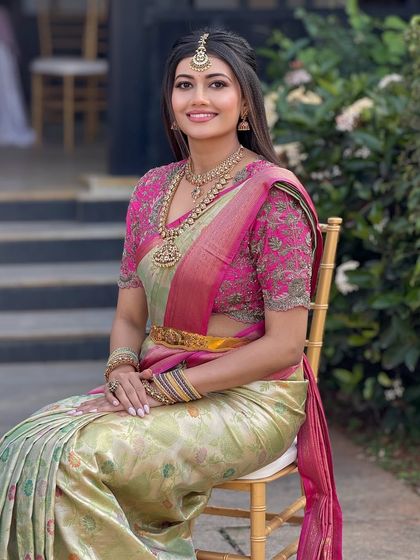 A full-length portrait of the bride seated, showcasing her complete look from head to toe.