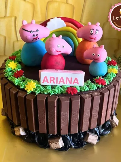 I love creating cakes based on beloved children's characters, like this Peppa Pig cake. It features a KitKat border and handcrafted fondant figures of the whole family, making it a delightful and delicious centerpiece for a young child's party.