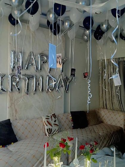 A close-up of the personalized details, with photos hanging from the balloons over the decorated seating area.