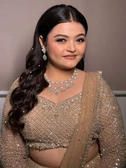 This client is glowing in her engagement makeup and hair. The soft curls frame her face beautifully, and the makeup enhances her features without feeling heavy, perfect for celebrating her special day.