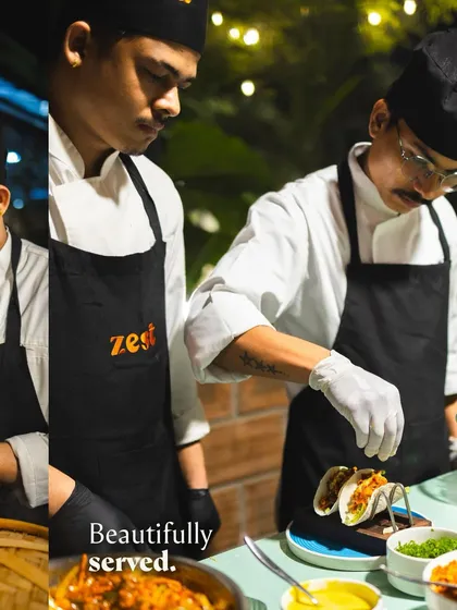 A chef carefully assembles fresh tacos at a live station, ensuring every component is perfect.