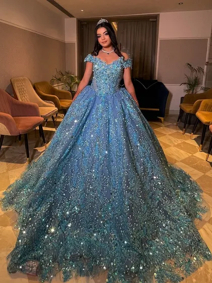 Our gorgeous client looking like a true princess in our sparkling turquoise ball gown. The off-shoulder design and voluminous skirt create a stunning silhouette, perfect for making a grand entrance at her engagement party.