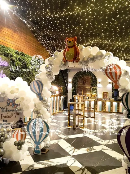A dreamy entrance for a "Twinkle Twinkle Little Star" themed party. The arch is made of white and silver balloons, with hot air balloon and teddy bear props creating a magical welcome under a ceiling of fairy lights.