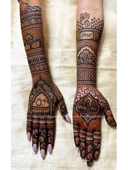 A sweet and personal design featuring engagement rings and the bride's name 'Ankita'. The arms are decorated with swans and the tree of life.