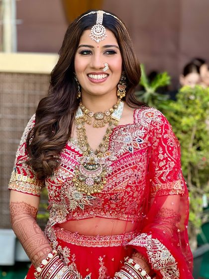 The complete look for Bhavi, showcasing her elegant red lehenga and our signature soft glam makeup. It's a perfect example of a classic yet modern Indian bridal style.