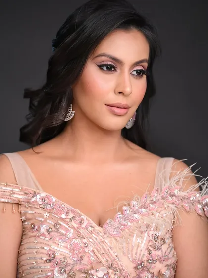 This pose highlights the soft contouring and the feathered details on the dress.