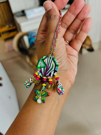 Holding the handmade Lumba in my hand. You can see the colorful, hand-woven thread and the delicate details that make it a perfect gift for your bhabhi.